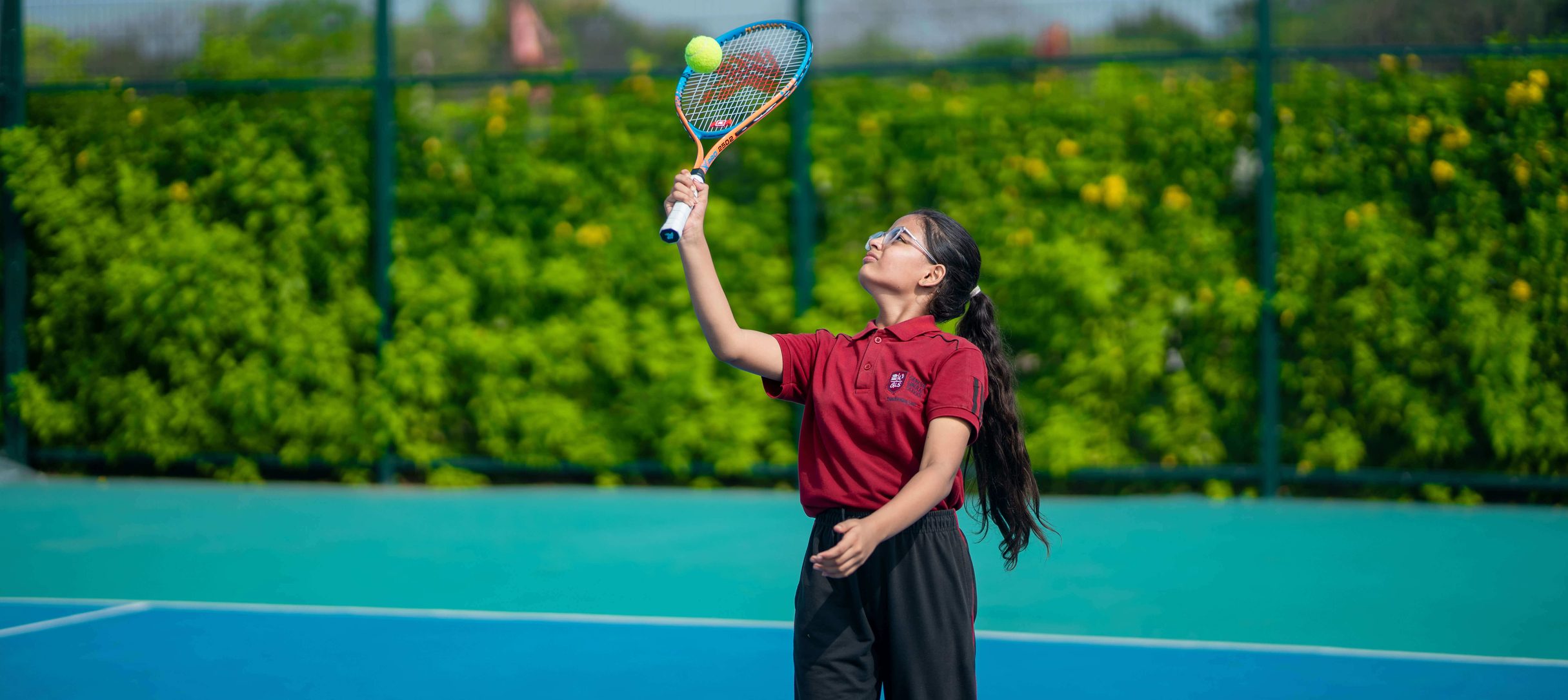 Students playing tennis on the school court