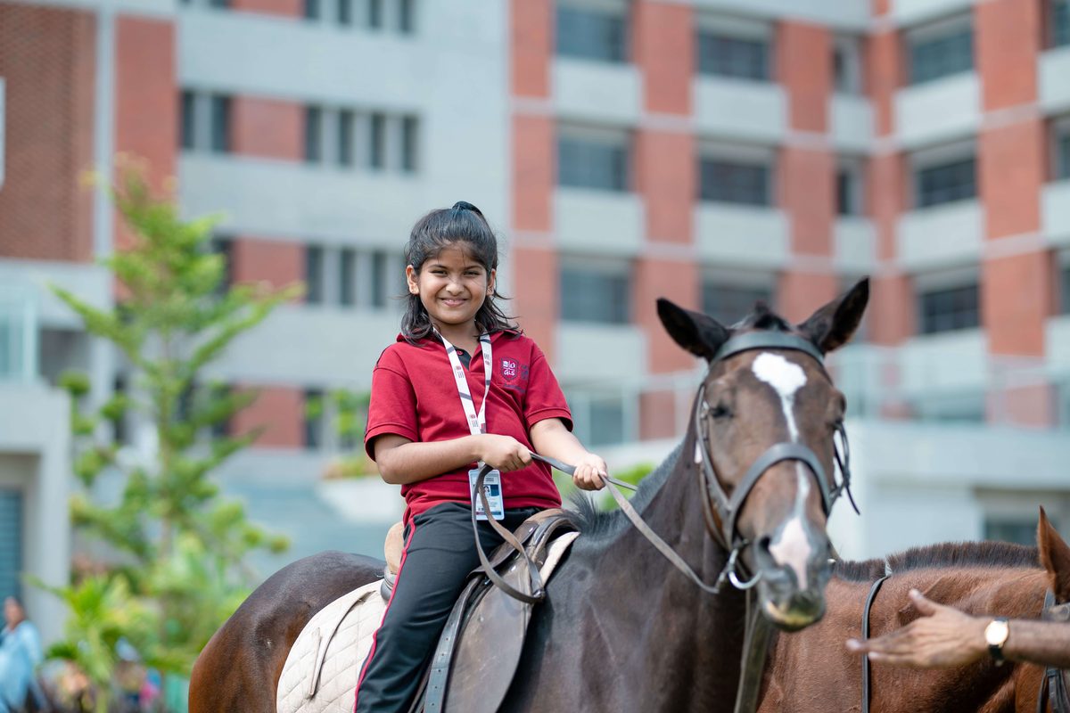 Student horse riding on the school campus