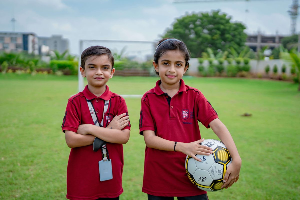 Two students with a football on the school ground