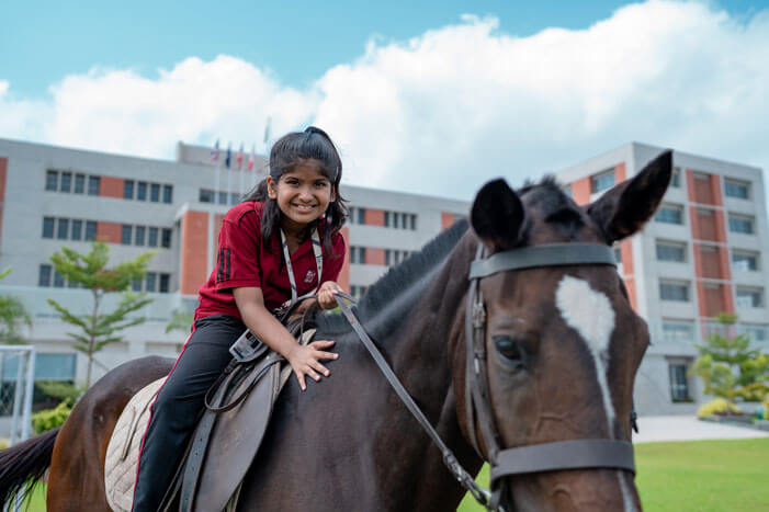 Student horse riding on the school campus