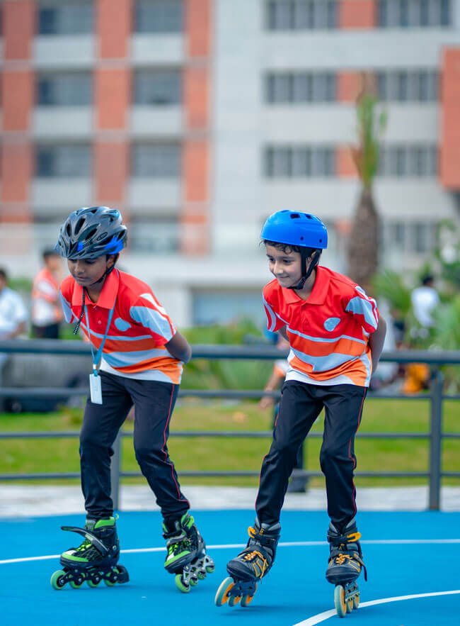Two students inline skating on the campus rink