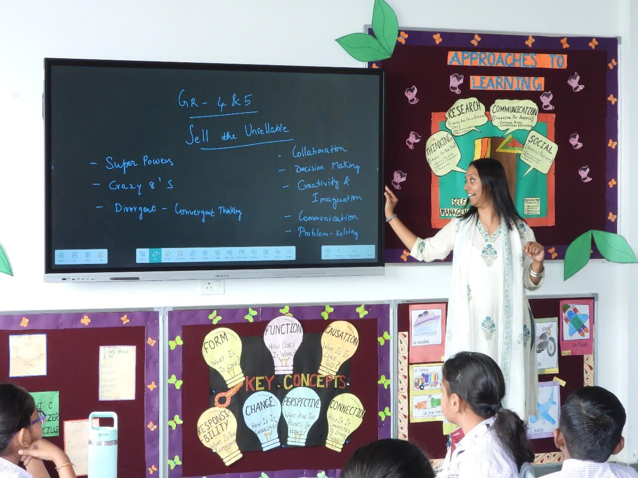 Teacher leading a StartupYou entrepreneurship lesson at the interactive board