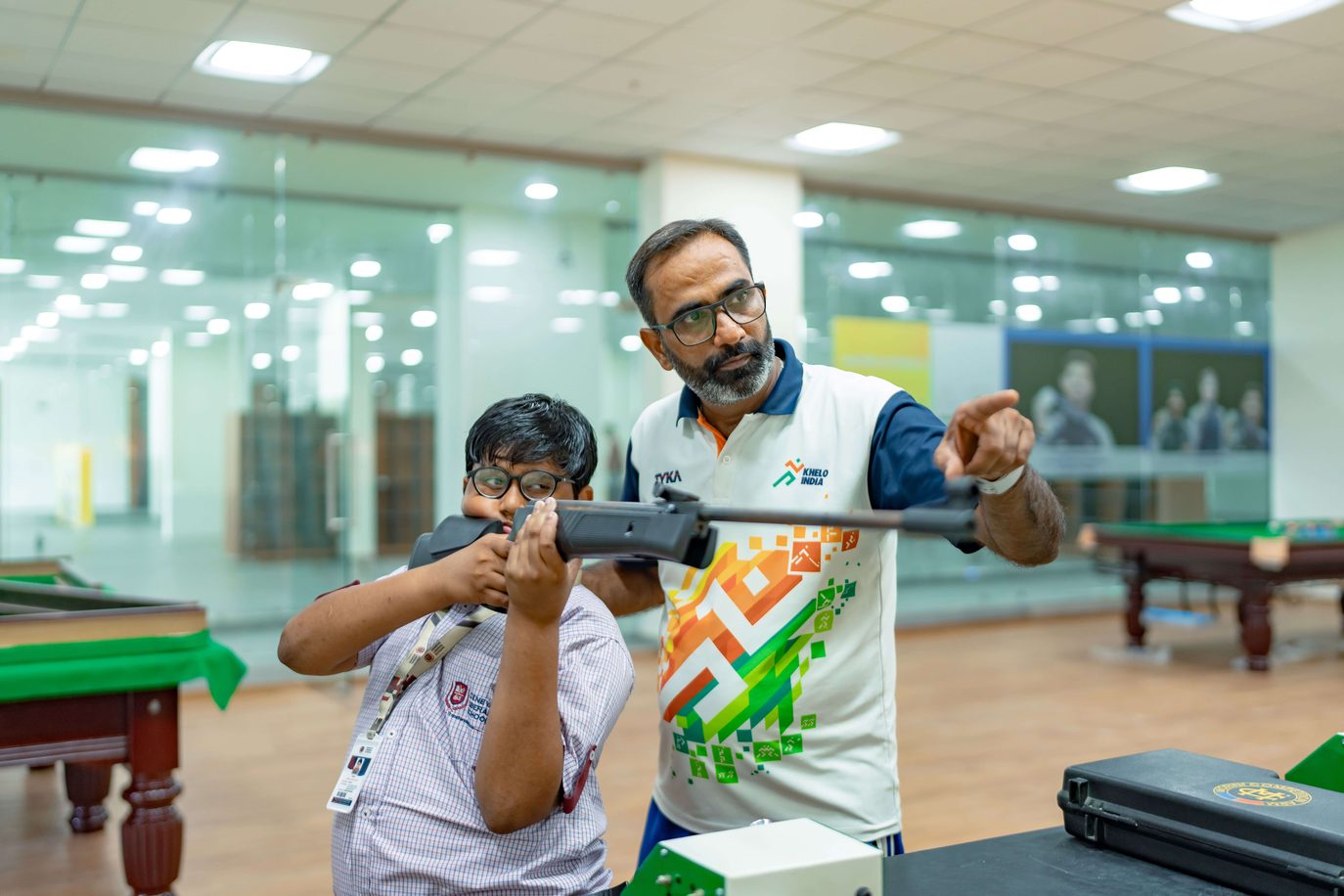 Coach guiding a student at the school shooting range